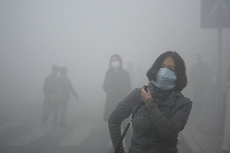 A woman wearing a mask walk through a street covered by dense smog in Harbin, northern China, Monday, Oct. 21, 2013. Visibility shrank to less than half a football field and small-particle pollution soared to a record 40 times higher than an international safety standard in one northern Chinese city as the region entered its high-smog season. (AP Photo/Kyodo News) JAPAN OUT, MANDATORY CREDIT